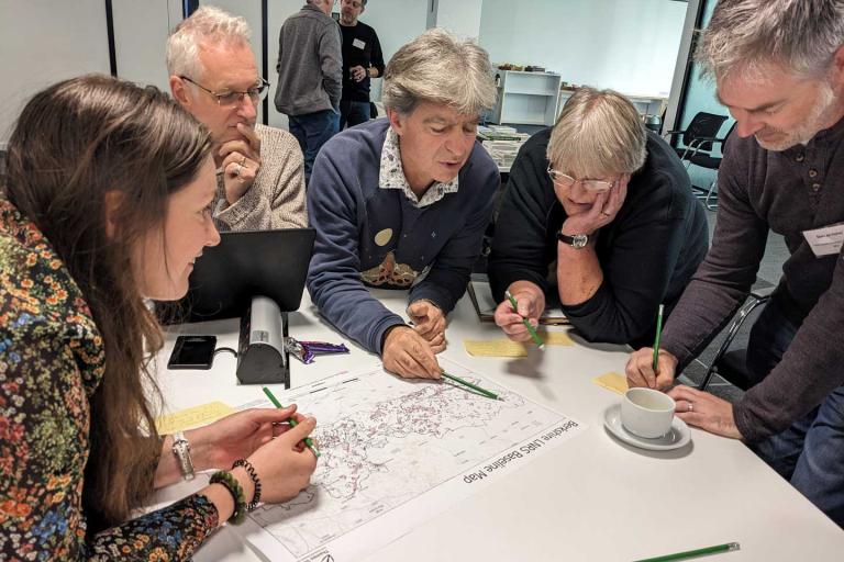 a group of people gathered around a map of Berkshire for training